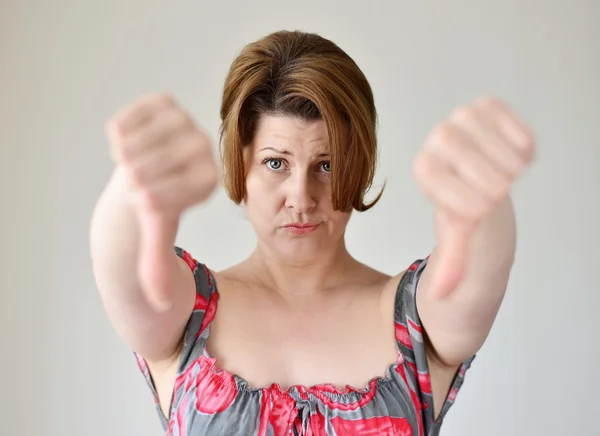 Angry young woman showing thumb down — Stock Photo, Image