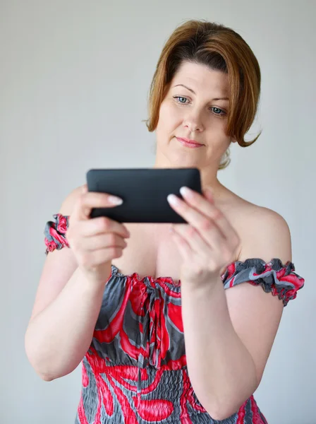 Доросла жінка дивиться на мобільний телефон — стокове фото