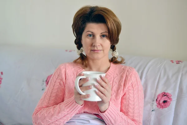 Woman with flu symptoms holding a cup in  hand — Stock Photo, Image