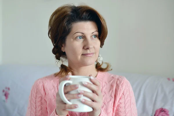 Женщина с симптомами гриппа держит чашку в руке — стоковое фото