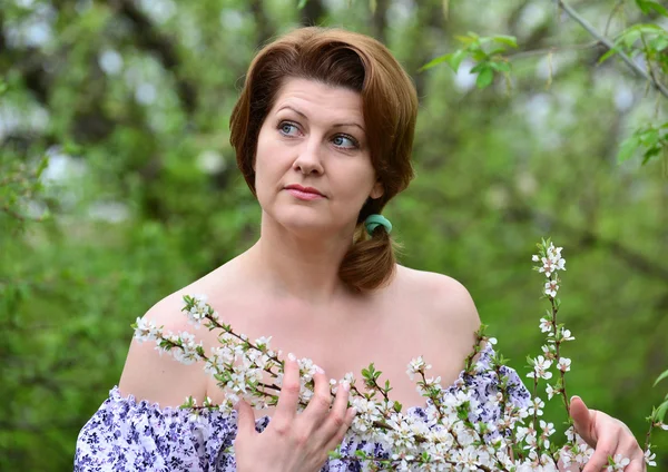 Mujer adulta cerca de las flores de cerezo — Foto de Stock