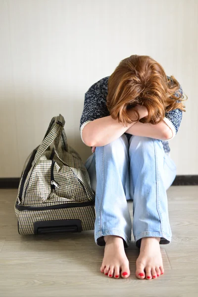 Traurige Frau sitzt wegen Scheidung mit Koffer an der Wand — Stockfoto