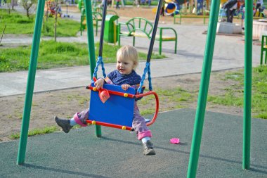  küçük kız açık salıncakta eğleniyor