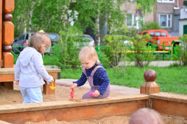Kum havuzunda oynayan iki küçük kız