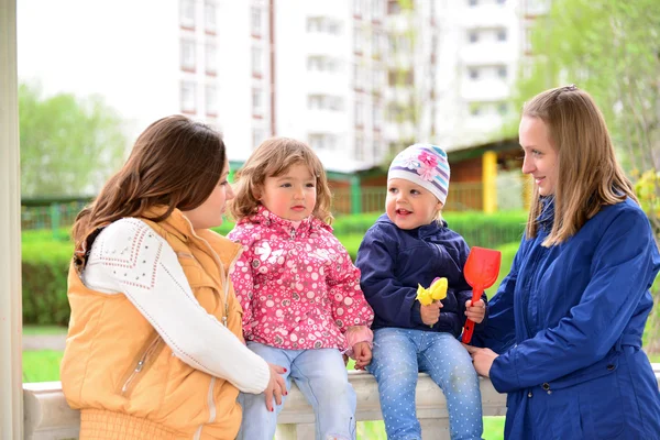 Две матери с детьми на прогулке в беседке — стоковое фото