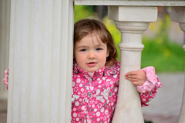 Dos años de edad, niña mira hacia fuera desde gazebo — Foto de Stock