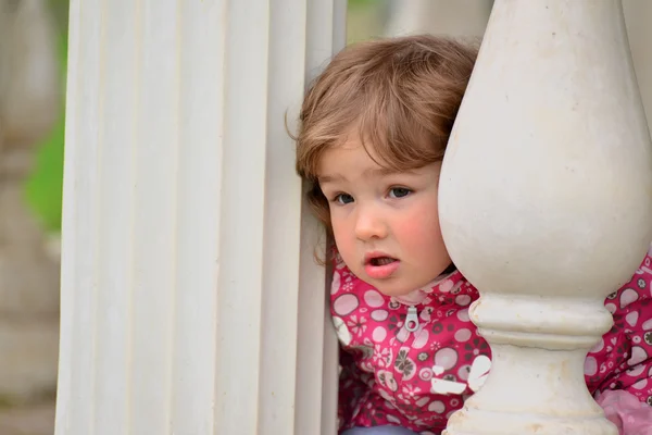 Dois anos de idade menina olha para fora de gazebo — Fotografia de Stock