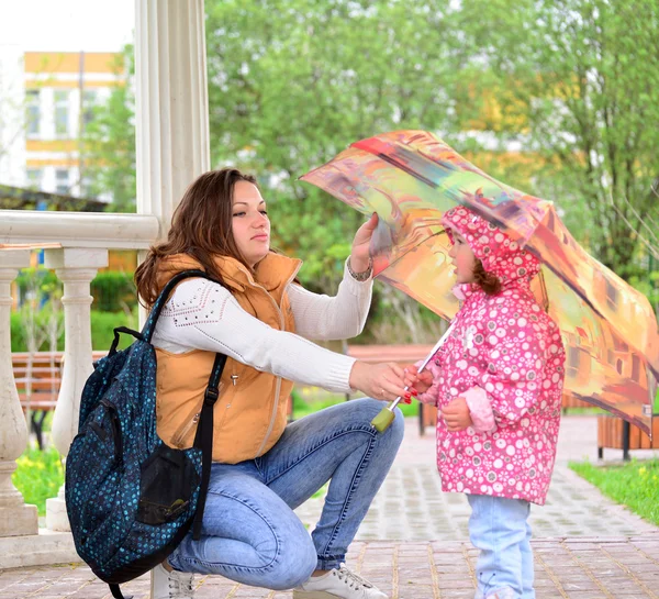 Mother  with her daughter and  umbrella in arbor — Stock Photo, Image