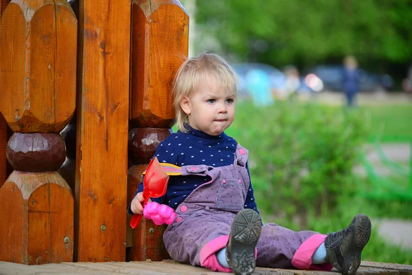 Двухлетняя девочка на скамейке в парке — стоковое фото