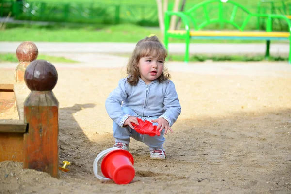 Klein meisje in de zandbak spelen — Stockfoto