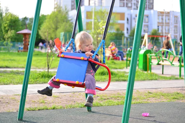 Niña divirtiéndose en un swing al aire libre — Foto de Stock