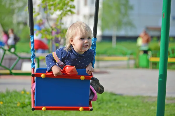 Niña divirtiéndose en un swing al aire libre — Foto de Stock