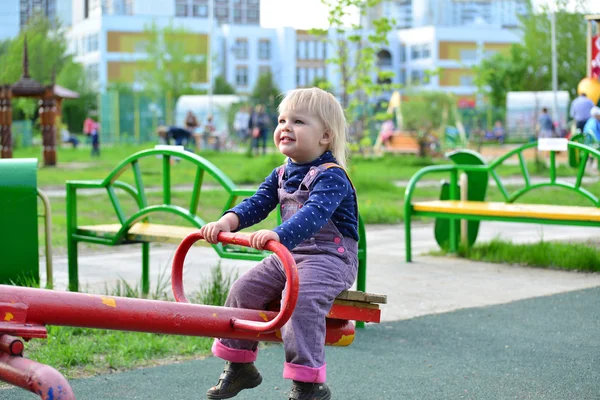 Liten flicka att ha kul på en gunga utomhus — Stockfoto