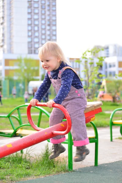 Kleines Mädchen hat Spaß auf einer Schaukel im Freien — Stockfoto