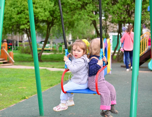 Twee meisje op swing rit — Stockfoto