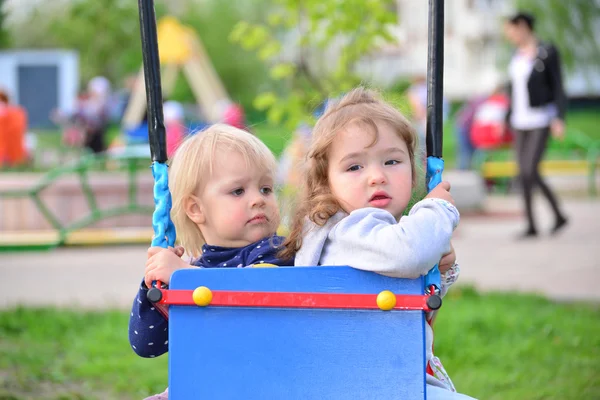 Zwei kleine Mädchen auf Schaukelfahrt — Stockfoto