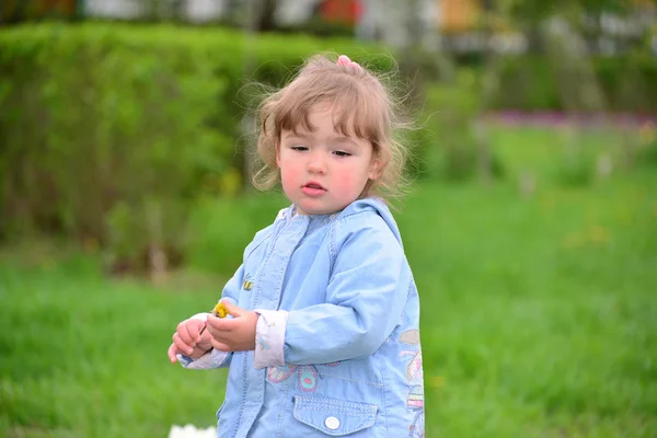 Cute baby girl with blonde curly hair outdoors. — Stock Photo, Image