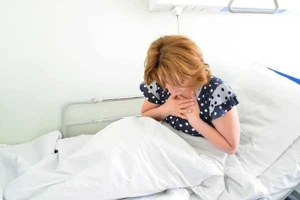 Vrouwelijke patiënt met oprechte pijn liggend op bed in het ziekenhuis ward — Stockfoto