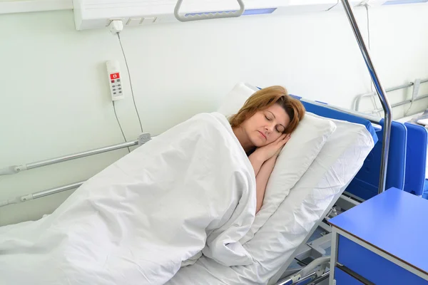 Paciente feminina deitada na cama na enfermaria do hospital — Fotografia de Stock