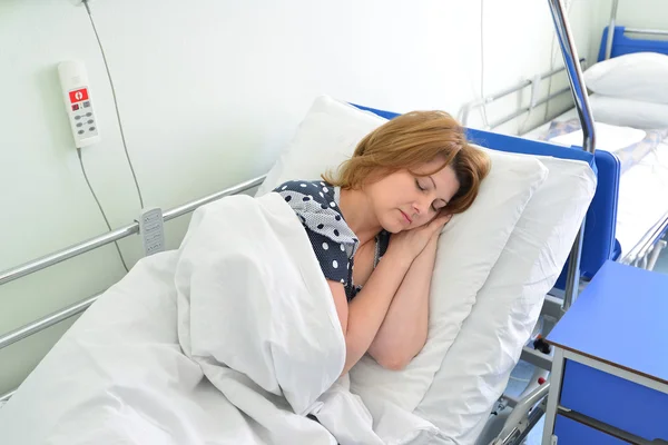 Paciente feminina deitada na cama na enfermaria do hospital — Fotografia de Stock