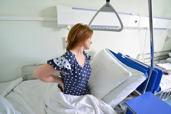 Female patient with back pain on  bed in hospital ward — Stock Photo, Image