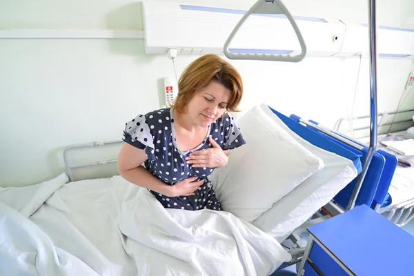 Female patient With heartfelt pain lying on  bed in hospital ward — Stock Photo, Image