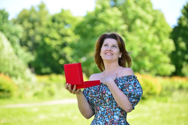 Nette Frau mit Geschenk im Sommerpark — Stockfoto