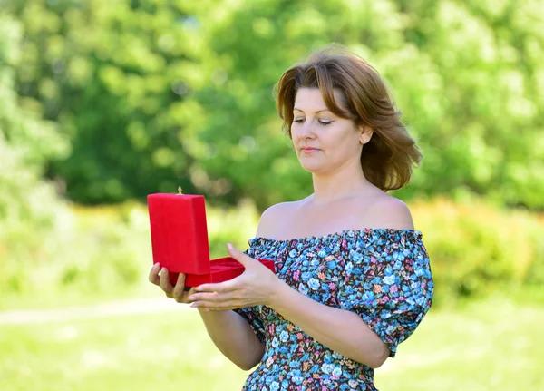 Leuke vrouw met cadeau in zomer park — Stockfoto