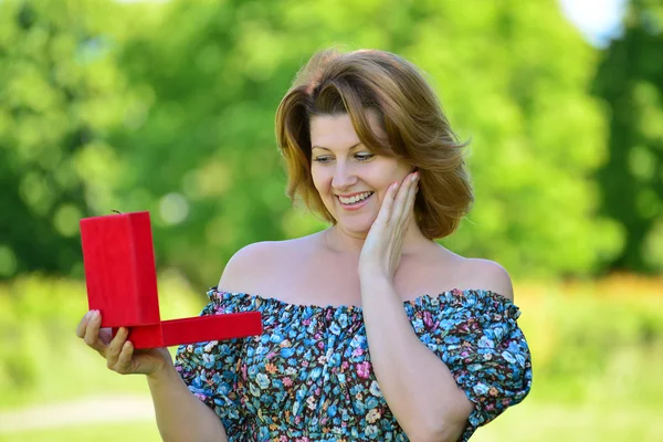 Mujer linda con regalo en el parque de verano — Foto de Stock