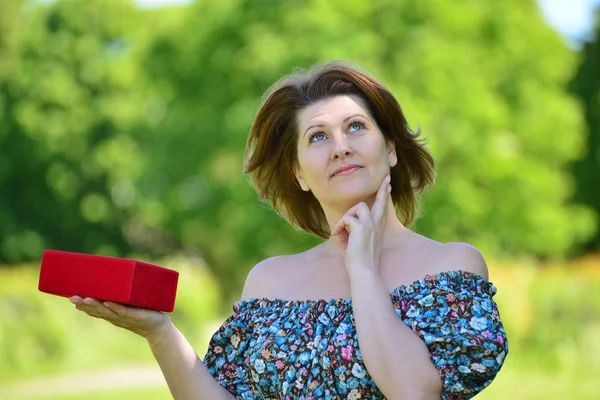 Mujer linda con regalo en el parque de verano — Foto de Stock