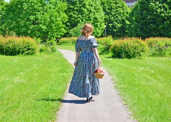 公園でフルーツのバスケットを持つ大人の女性 — ストック写真