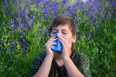 teen boy with allergies in flowering herbs clipart