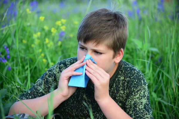 Teen boy with allergies in flowering herbs — Stock Photo, Image