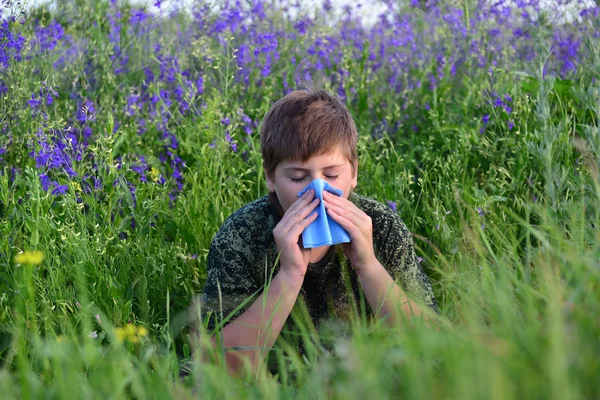 Adolescent garçon avec des allergies dans les herbes à fleurs — Photo