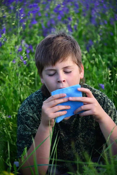 Teen boy with allergies in flowering herbs — Stock Photo, Image