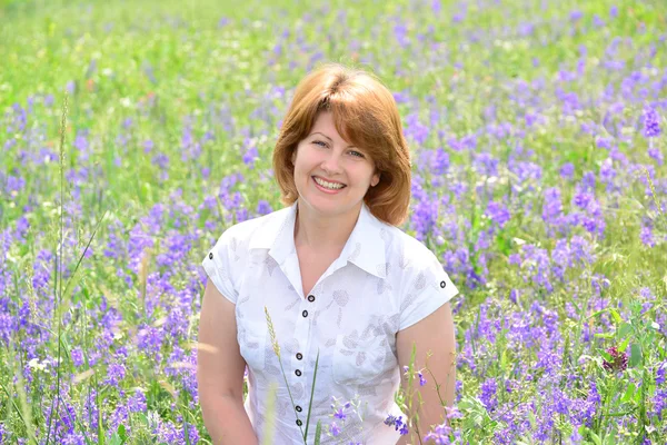 Femme adulte dans la prairie avec des fleurs sauvages — Photo