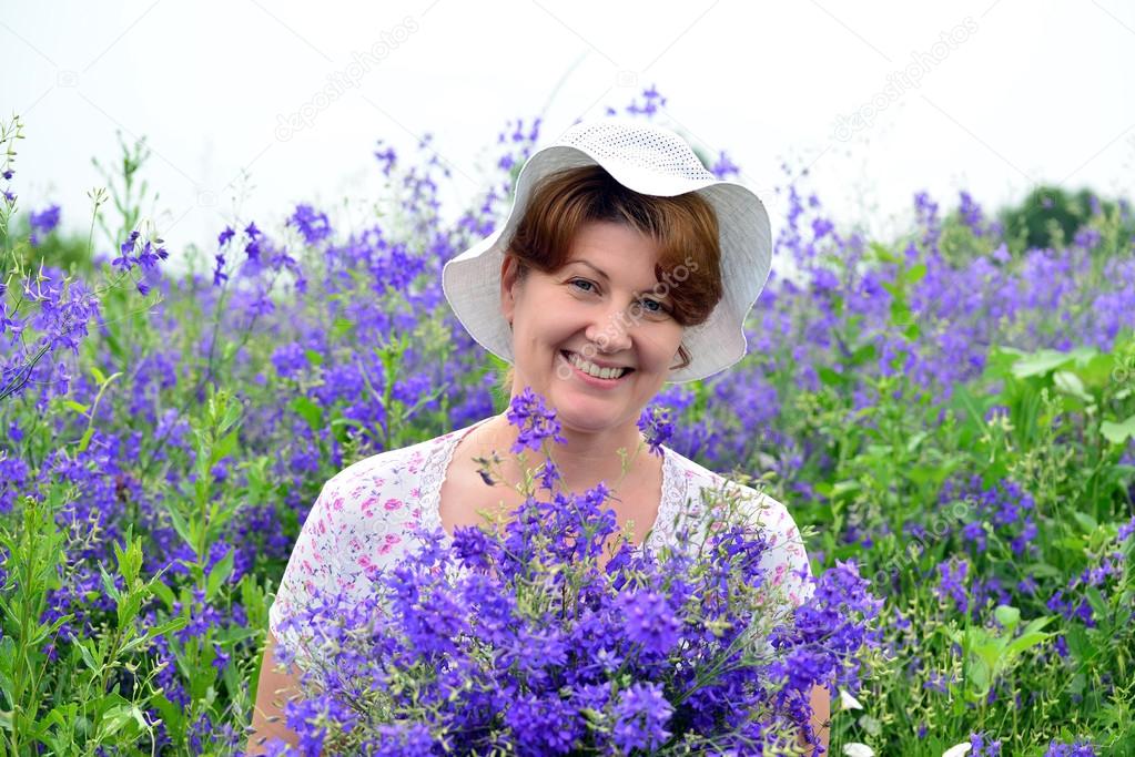 Woman with a bouquet of wild flowers on the lawn