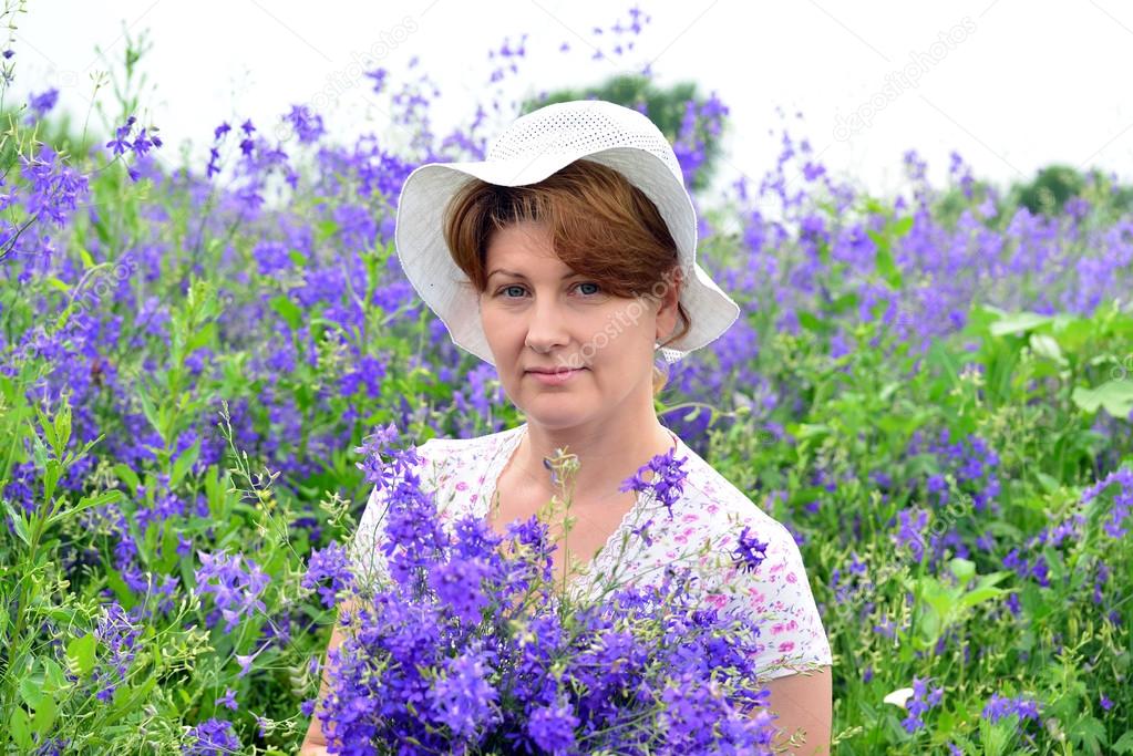 Woman with a bouquet of wild flowers on the lawn