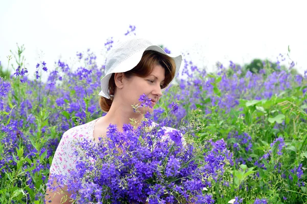 Femme avec un bouquet de fleurs sauvages sur la pelouse — Photo