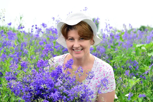 Femeie cu un buchet de flori sălbatice pe gazon — Fotografie, imagine de stoc