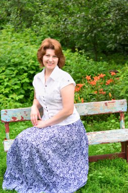  bahçede bir bankta oturan yetişkin kadın