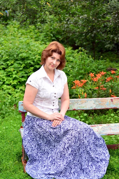 성인 여자는 정원에서 벤치에 앉아 — 스톡 사진
