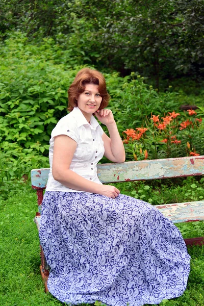Dospělé ženy, sedící na lavičce na zahradě — Stock fotografie