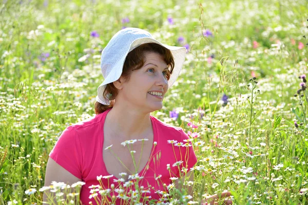 Frau auf einer Wiese mit Gänseblümchen — Stockfoto