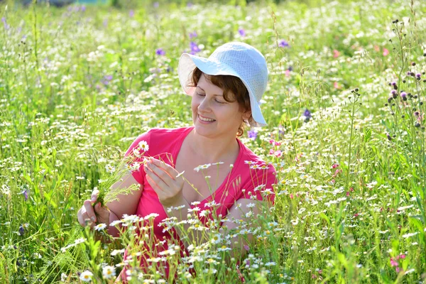 Vrouw op een weiland met madeliefjes — Stockfoto