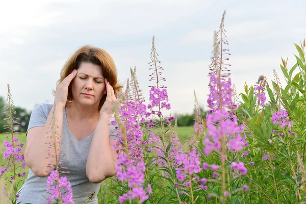 Retrato de mujer con dolor de cabeza cerca de sauce-hierba en el campo — Foto de Stock