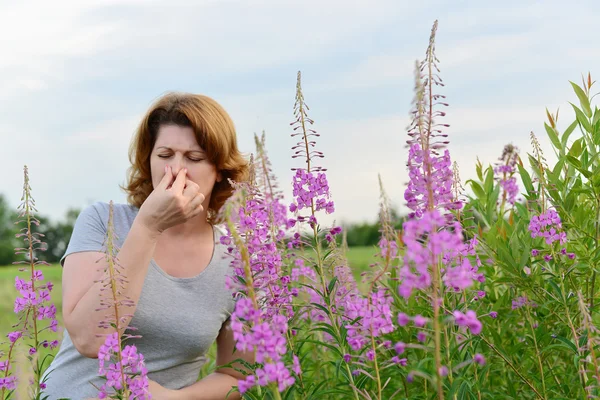 Porträt einer Frau mit allergischem Schnupfen in der Nähe von Weidenkraut im Feld — Stockfoto