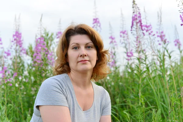Portrait of  woman near willow-herb in the field — Stock Photo, Image