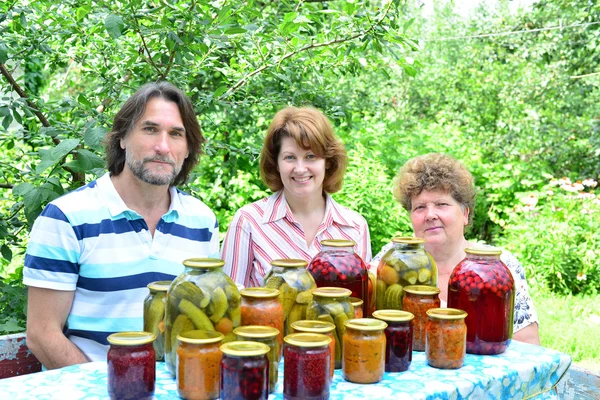 Família com legumes enlatados caseiros na natureza — Fotografia de Stock