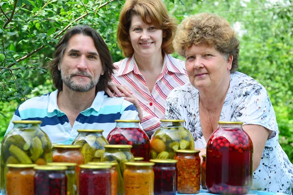 Família com legumes enlatados caseiros na natureza — Fotografia de Stock